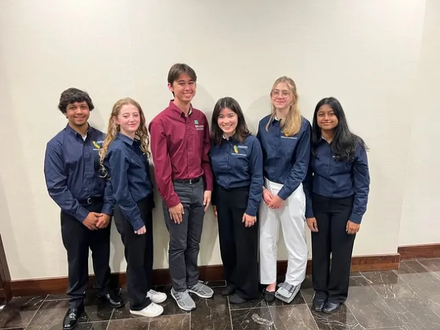 five youth in matching navy blue long sleeve shirts