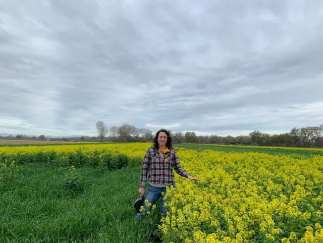 Sarah Light next to a cover crop plot