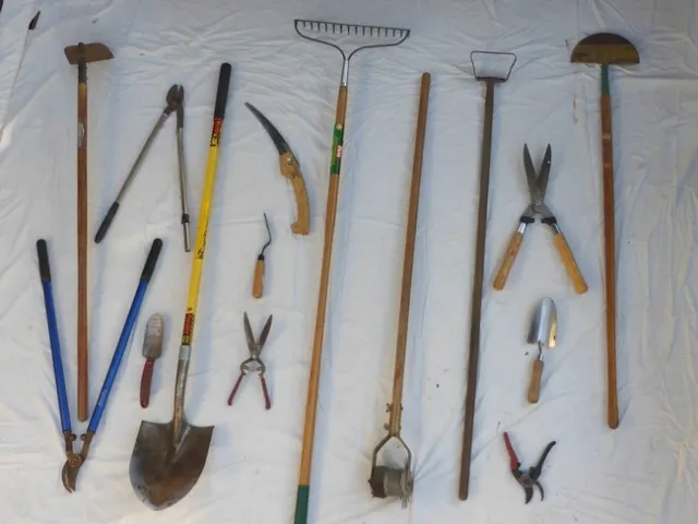Tools ready for sharpening, including pruners, hoes, rakes, and shovels.