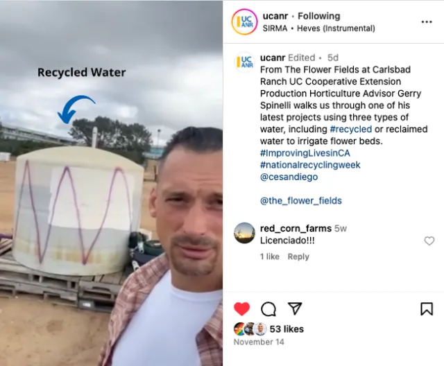 Gerry films himself in a field with three tanks of water behind him. One tank is labeled 