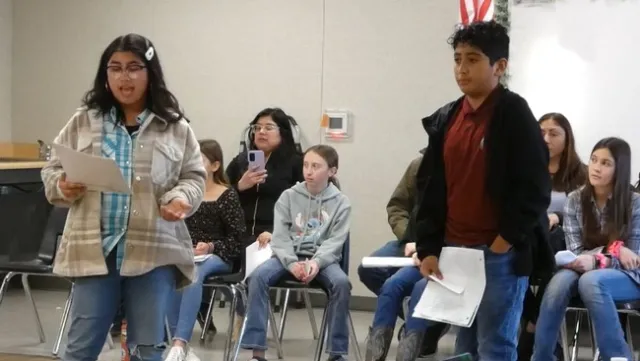 Two students speak in front of a school board