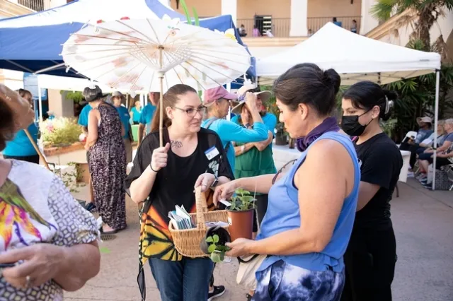 Leah Taylor distribuye volantes entre los asistentes a Venta Anual de Plantas del 2022 en el parque Balboa. Fotografía por Rob Padilla.