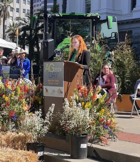 4-H State Ambassador Laurelyn speaking on stage.