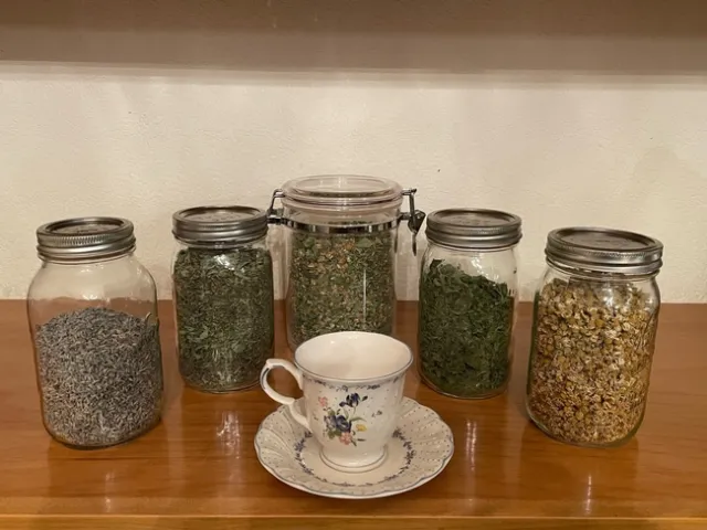 Clear jars filled with dried tea leaves and flowers.