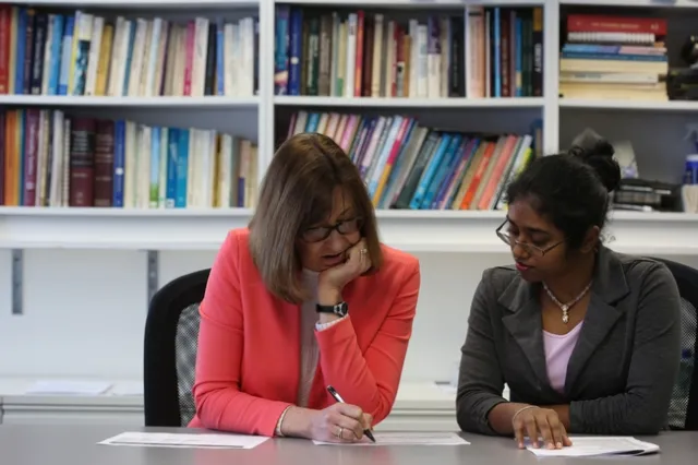 NPI director Lorrene Ritchie sits with Sri Hewawitharana in the NPI conference room