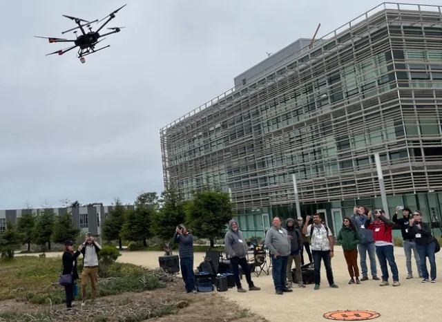 DroneCamp participants look up at drone flies overhead.