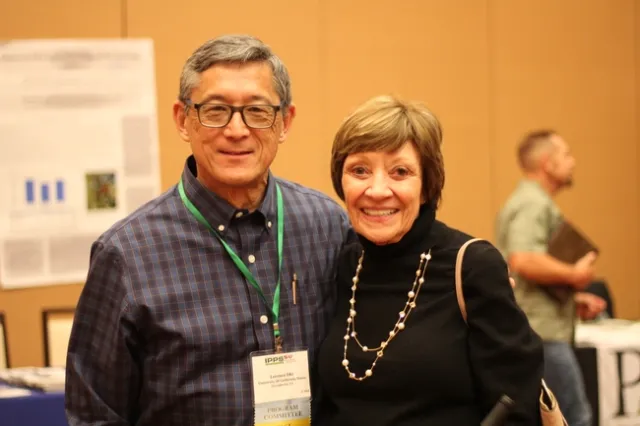 A man and woman smile at camera.