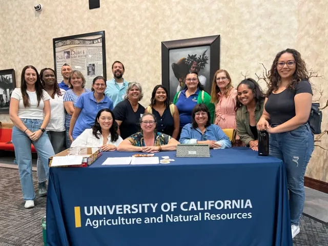 15 people from UC ANR standing aroud the registration table at the Pala Tribal Partnerships workshop