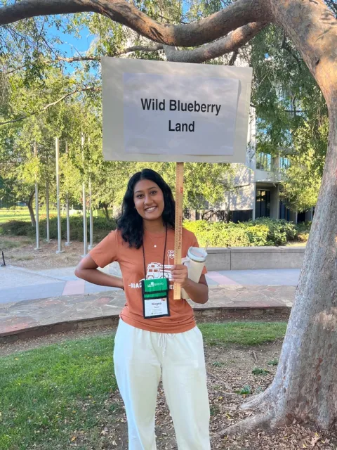 Megna holding sign saying