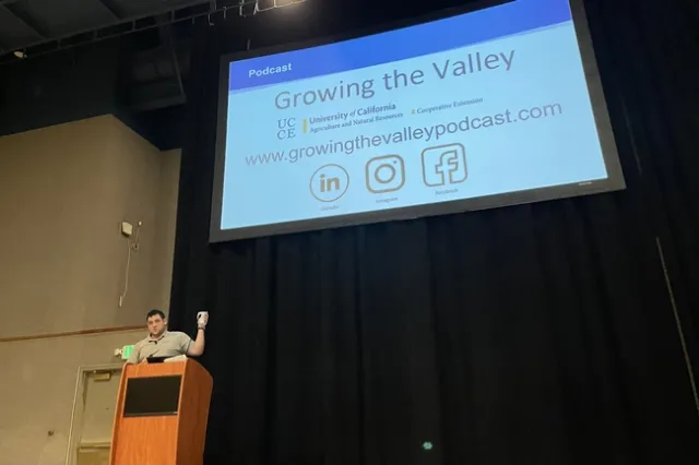 Man gestures to slide about growingthevalleypodcast.com