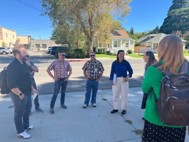 A group of people talk on a sidewalk in downtown Bishop, Inyo County