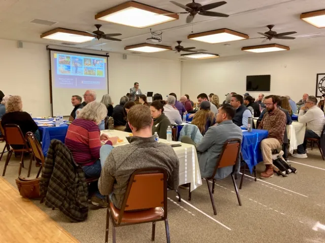 Swelam looks out to dozens of people seated at tables at West Side REC.