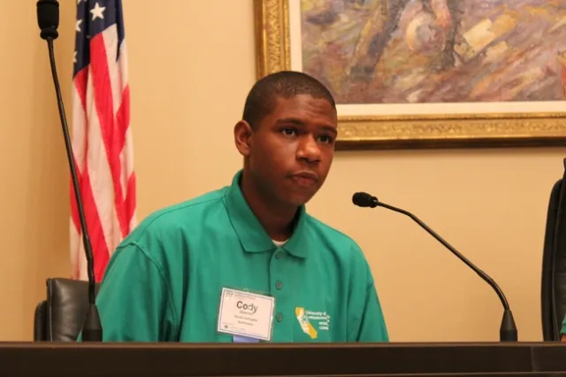 Cody speaking into a microphone