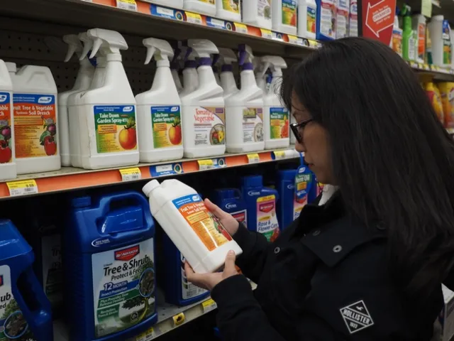 A dark haired woman holds a pesticide bottle in her hand to read it.