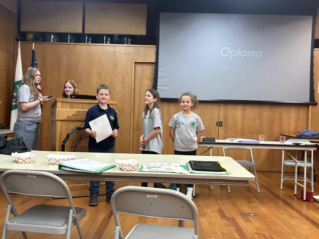 Ferndale 4-H Club youth, most in grey 4-H t-shirts, in the auditorium of the Ag Center preparing to give a presentation