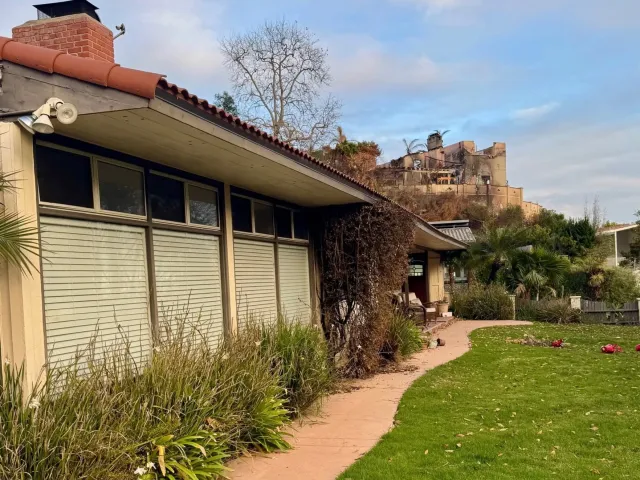 Casa con la vegetación intacta después del incendio en LA