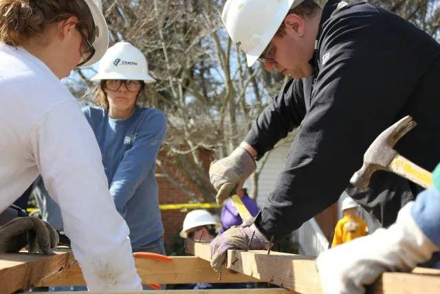 People doing construction together with hard hats on