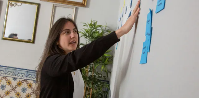 Facilitator pointing to white board notes