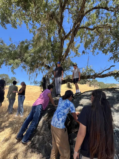 Tribal youth participants visit a Pomo archeological site amid Hopland REC woodlands