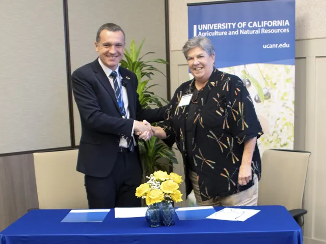 Òscar Ordeig and Glenda Humiston shake hands after signing MOU