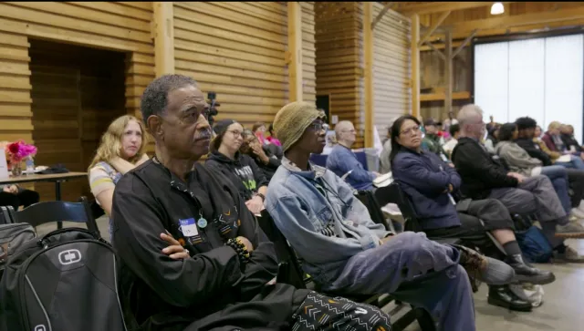 People sit in chairs in rows