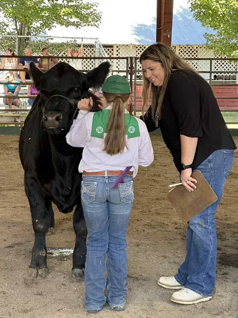 Tracy, on right, talks with a 4-H member who is showing a big black steer