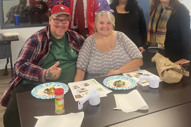 Burkes smile at a table during an EFNEP class