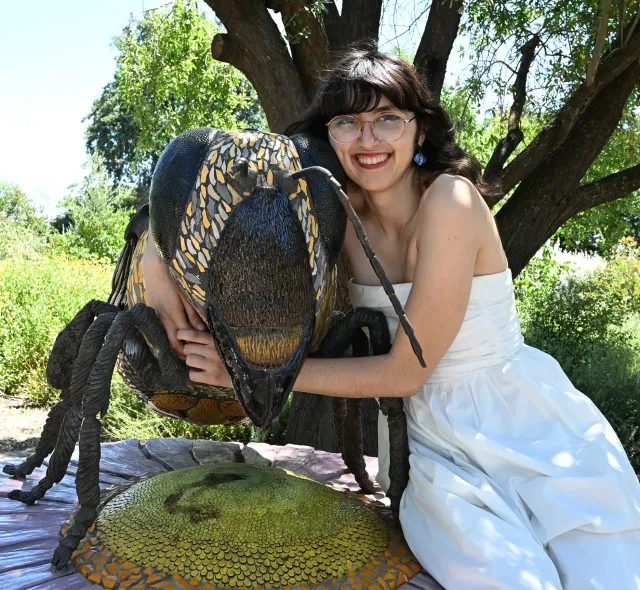 Samantha "Sam" Murray, education and garden coordinator of the UC Davis Bee Haven, with The Haven's bee sculpture, "Miss Bee Haven," the work of Donna Billick. (Photo by Kathy Keatley Garvey)