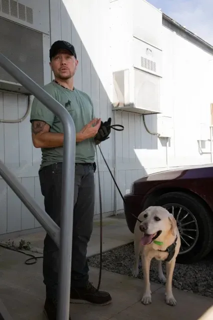 Man standing next to dog 