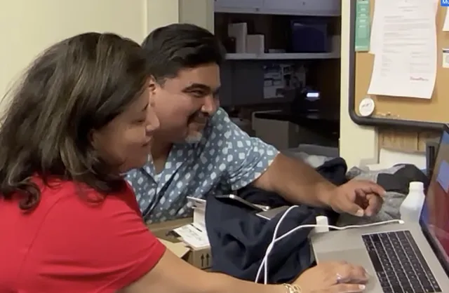Diana and Miguel working on a laptop