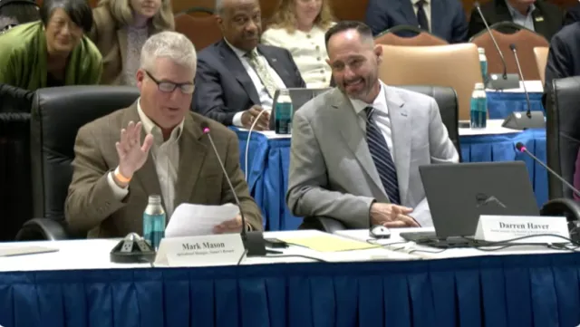 Mark Mason and Darren Haver sit at a table with mics
