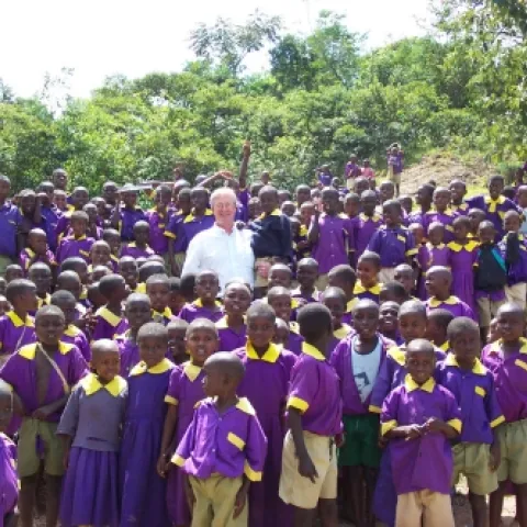 IN KENYA--UC Davis medical entomologist Thomas Scott, towers above schoolchildren in Kenya in a photo taken in 2004. (He's 6-foot, 6-inches tall.)