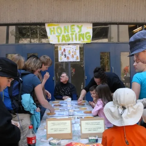 COOPERATIVE EXTENSION APICULTURIST Eric Mussen (center) answers questions about honey at the annual honey tasting table at Briggs Hall, UC Davis. (Photo by Kathy Keatley Garvey)