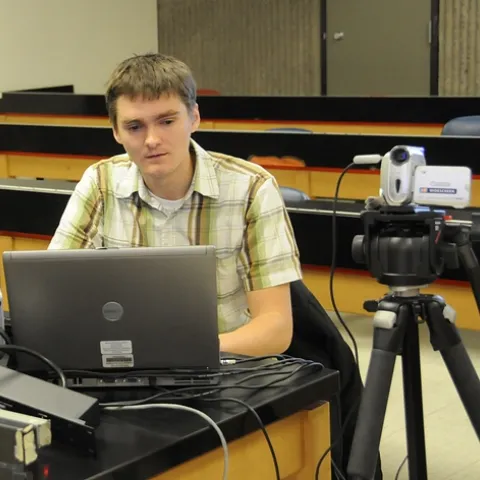 GRADUATE STUDENTS James Harwood (shown) and Amy Morice, who study with major professor James Carey of the UC Davis Department of Entomology, devote their lunch hours to Webcasting the departmental seminars. Here Harwood readies the equipment prior to a seminar. (Photo by Kathy Keatley Garvey)