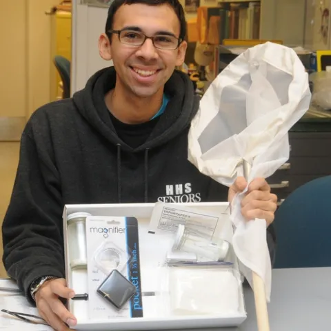 UC DAVIS entomology major Joel Hernandez, a student assistant at the Bohart Museum of Entomology, shows one of the insect collection kits available in the gift shop. Martha Stewart listed the Bohart Museum insect collection kit as one of the top three gifts to get young naturalists. Hernandez acquired one at age 7. (Photo by Kathy Keatley Garvey)