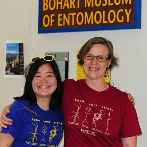 Ivana Li (left) and Fran Keller wearing their "Know Your Sticks" t-shirts. Note the real walking stick insects. (Photo by Kathy Keatley Garvey)