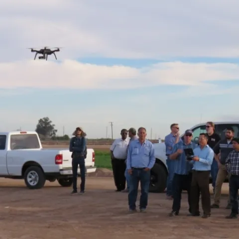 Participants at an IGIS drone workshop at Desert Research and Extension Center gain practice flying a drone.