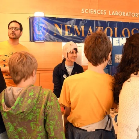 UC Davis diagnostic parasitologist Lauren Camp wears a papier mache nematode hat, modeled after a hookworm mouth. At left is nematologist Chris Pagan, a graduate student in entomology. (Photo by Kathy Keatley Garvey)