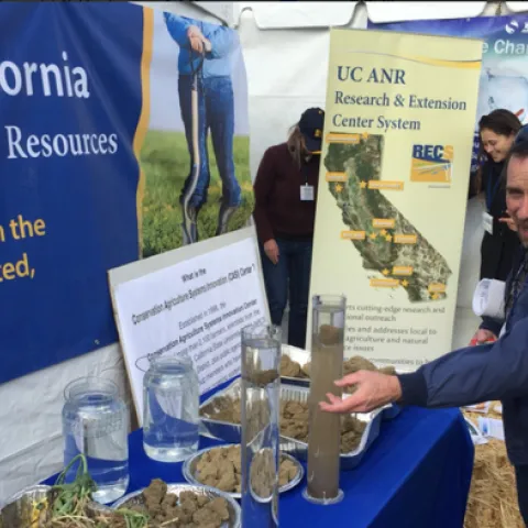 World Ag Expo visitors discuss conservation tillage at Jeff Mitchell's exhibit at the UC ANR tent.