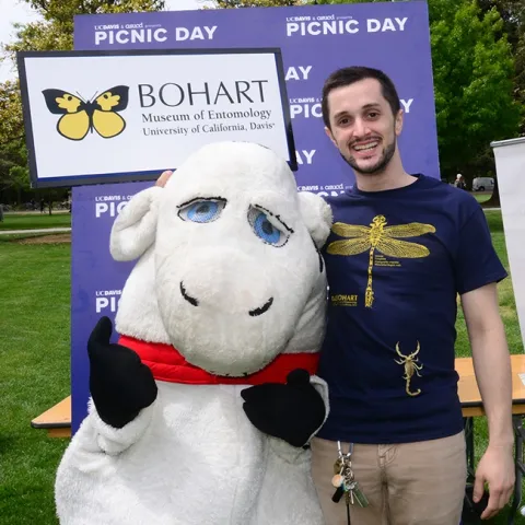 Bohart Museum associate Wade Spencer with his desert hair scorpion, Celeste, poses with the mascot, "Hamburger Cow Patty." (Photo by Kathy Keatley Garvey)