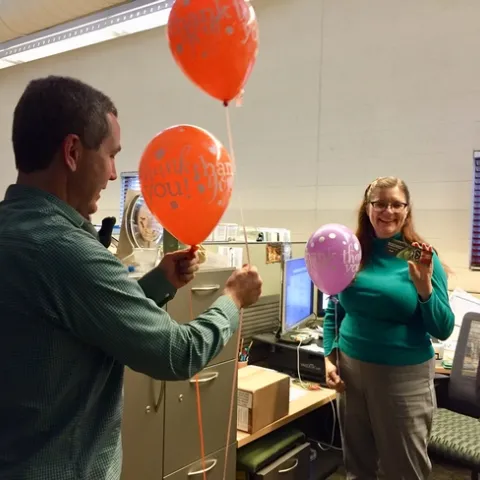 Scott Brayton of Development Services delivers a balloon to Belinda Messenger-Sikes of IPM.