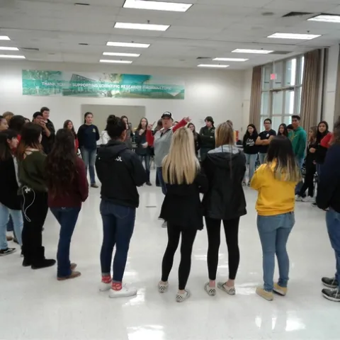 The students circle in a team-building exercise.