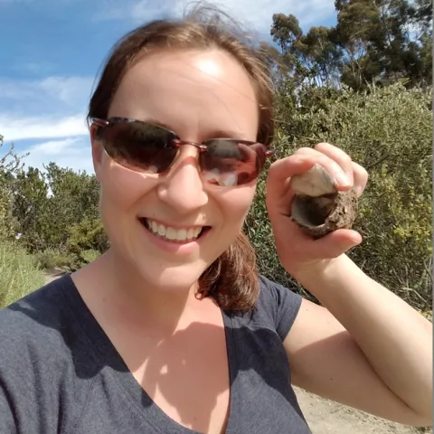 UC Davis doctoral student Rebecca Godwin holds the excavated burrow of the California trapdoor spider, Bothriocyrtum californicum, that she found in Chula Vista, in San Diego.