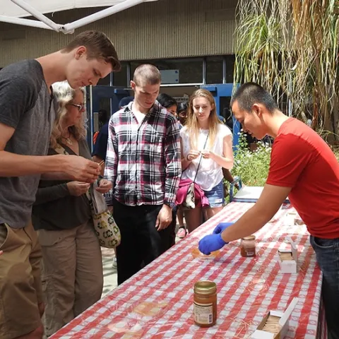 Graduate student Yao Cai (right) serves honey at the 2018 Picnic Day activities in Briggs Hall. (Photo by Kathy Keatley Garvey)