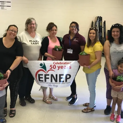 Six adults and 2 kids hold containers of plants. EFNEP & UC Master Gardener collaboration helped parents with children to learn about container gardening!
