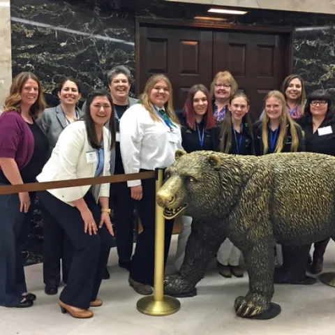 The UC ANR delegation, including Glenda Humiston and Wendy Powers, poses with the California bear statue outside the governor's office.