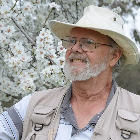 Robbin Thorp by an almond tree on Bee Biology Road, UC Davis. (Photo by Kathy Keatley Garvey)