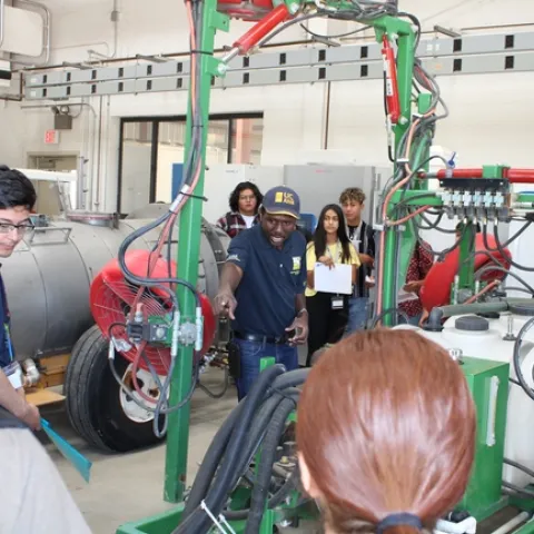 Dr. Peter Larbi interacting with student volunteers to demonstrating spray coverage during workshop.