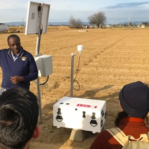 Isaya Kisekka explains to students how the small footprint cosmic ray measures soil water over a range of scales at the UC Davis research farm.