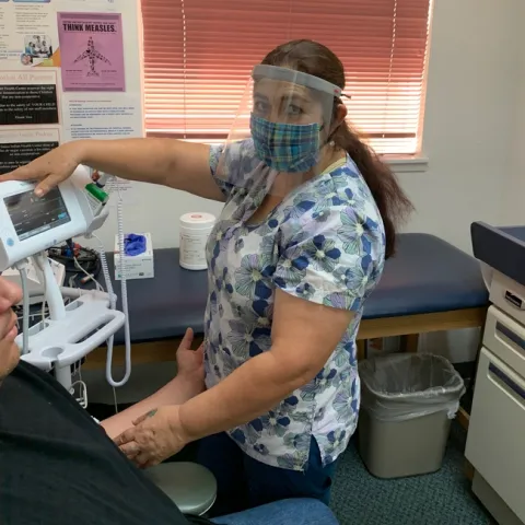 Health care worker with mask and face shield